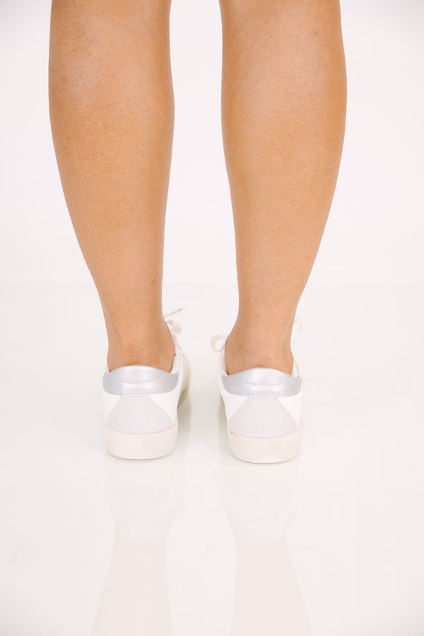 White low-top lace-up sneakers with a silver metallic base and a gold glitter star accent.