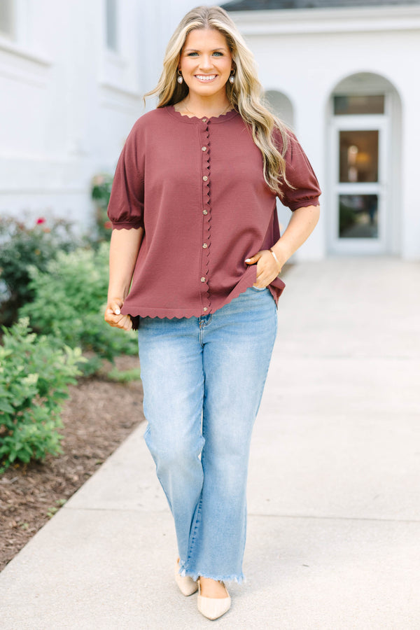 Plus size woman in a brown short sleeve cardigan with scalloped edges and a button-down front.