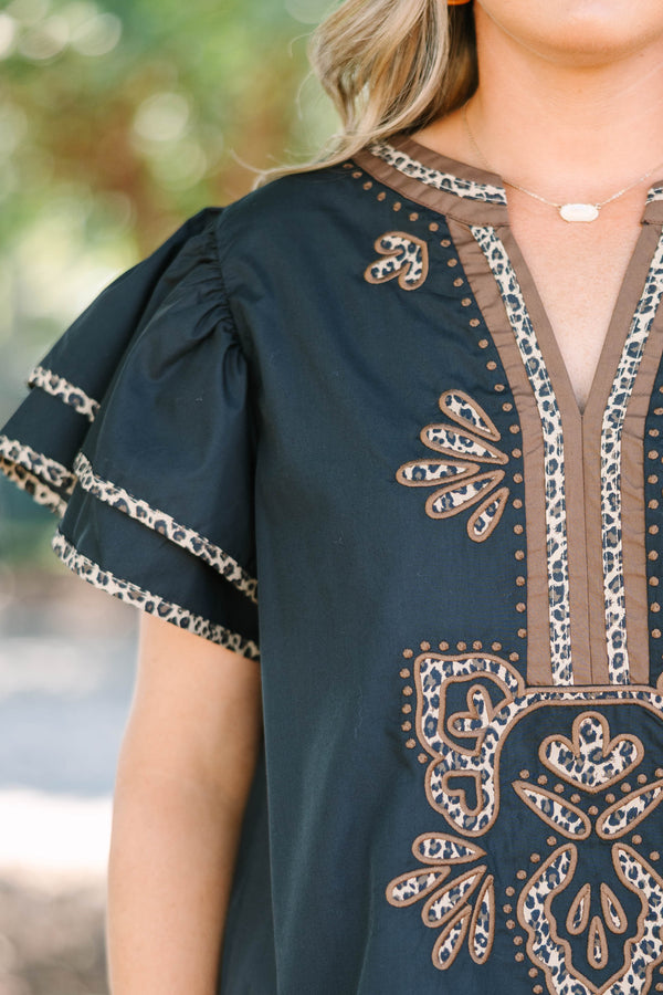 Plus Size black top with leopard print embroidery, V-neckline, and tiered flutter sleeves.