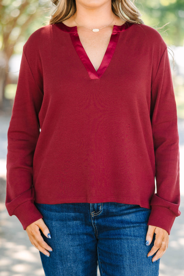 Plus Size burgundy long sleeve top with a ribbed texture and a satin-trimmed v-neckline.
