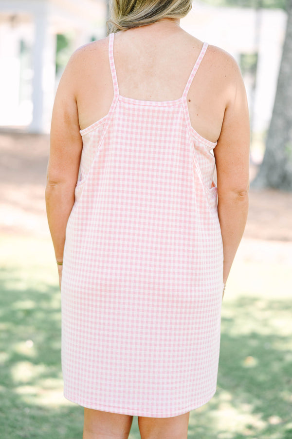 Plus size pink gingham athleisure dress with front pockets and a flowy, comfortable fit.