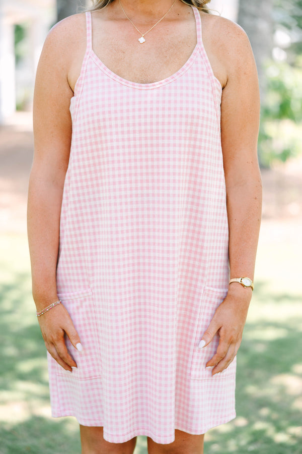 Plus size pink gingham athleisure dress with front pockets and a flowy, comfortable fit.