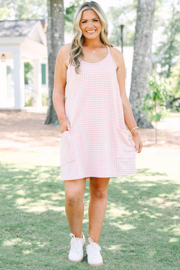 Plus size pink gingham athleisure dress with front pockets and a flowy, comfortable fit.
