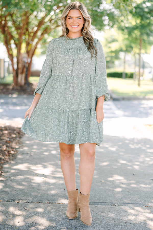 Plus size olive green tiered mini dress with white polka dots and a flowy, relaxed fit.
