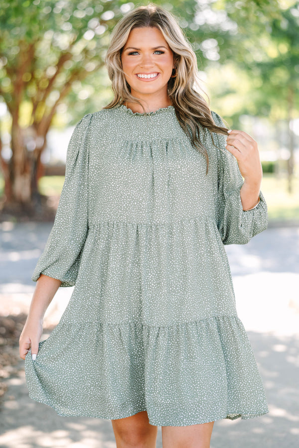 Plus size olive green tiered mini dress with white polka dots and a flowy, relaxed fit.
