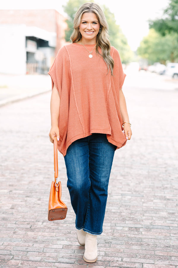 Plus size rust-colored, flowy knit sweater with a relaxed fit and short poncho sleeves.