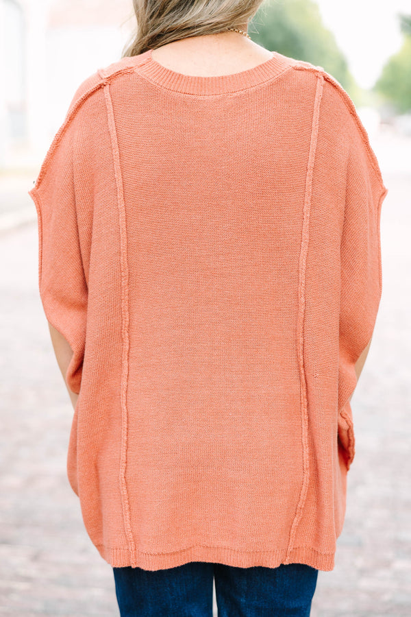 Plus size rust-colored, flowy knit sweater with a relaxed fit and short poncho sleeves.