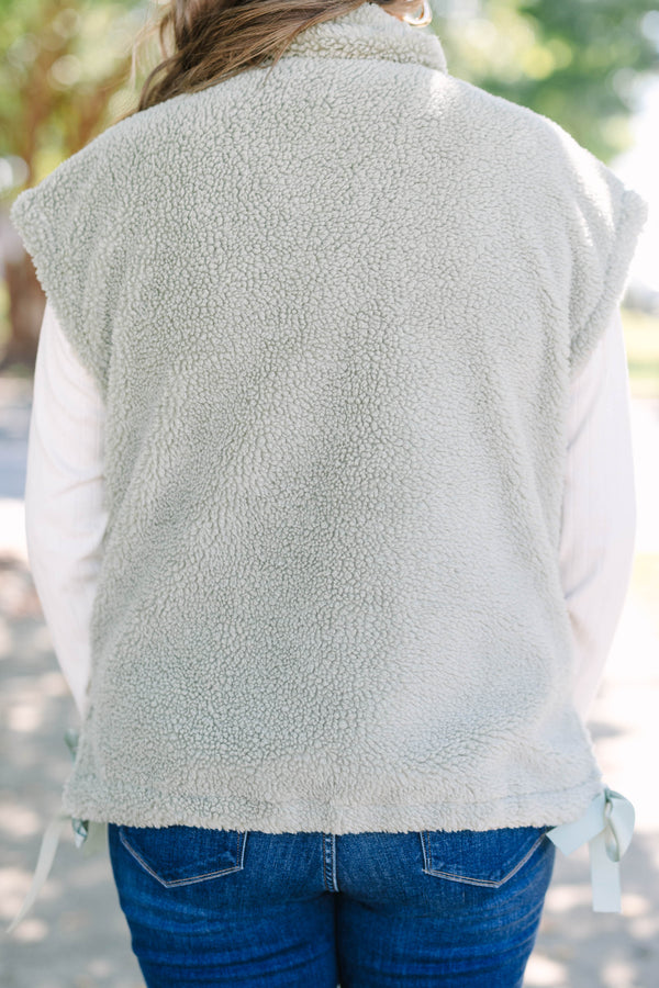 Plus size olive green sherpa vest with a zip-up front, snap buttons, and cozy textured fabric.