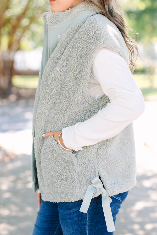 Plus size olive green sherpa vest with a zip-up front, snap buttons, and cozy textured fabric.