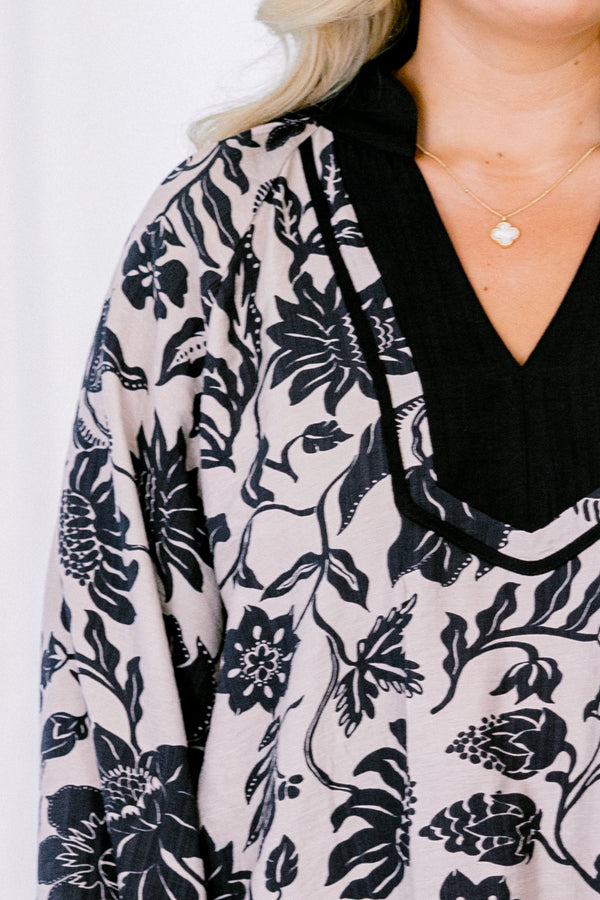 Chic Soul plus size clothing, taupe long sleeve blouse with a black floral pattern and black accents around the v-neckline 
