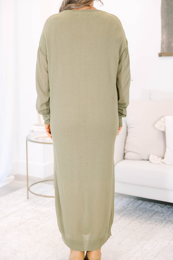 Plus size olive green midi dress with long sleeves, button neckline, and a brown belt.