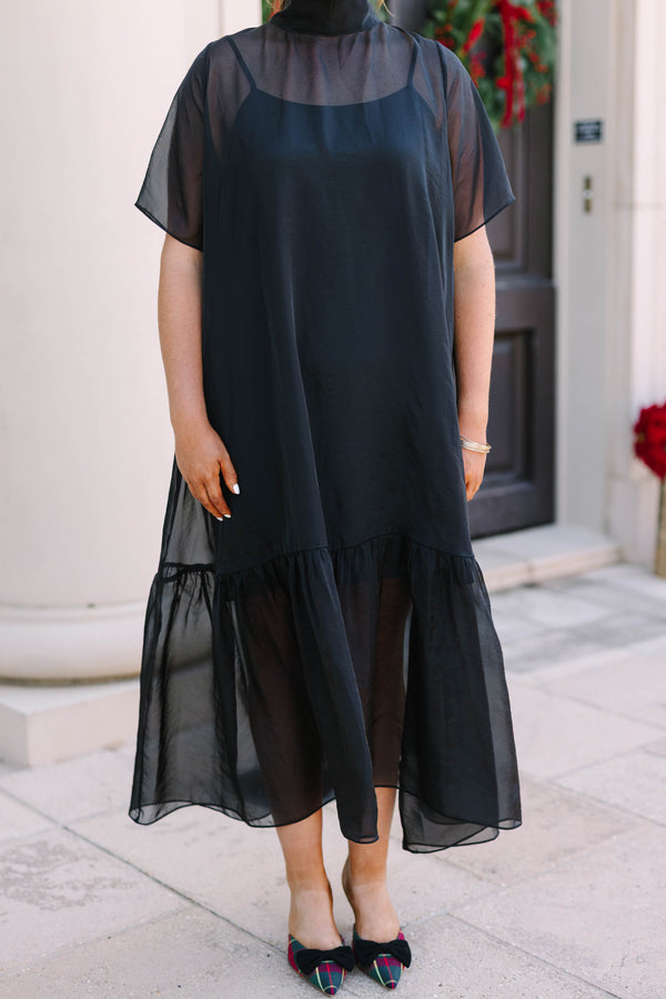 Plus Size black midi dress with a high neck, sheer overlay, short sleeves, and a ruffled hem.