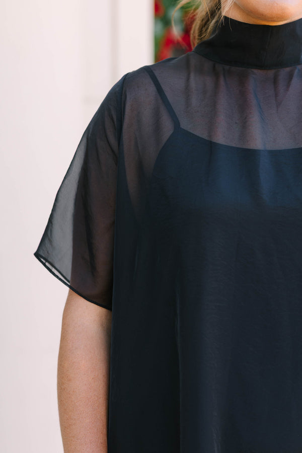 Plus Size black midi dress with a high neck, sheer overlay, short sleeves, and a ruffled hem.