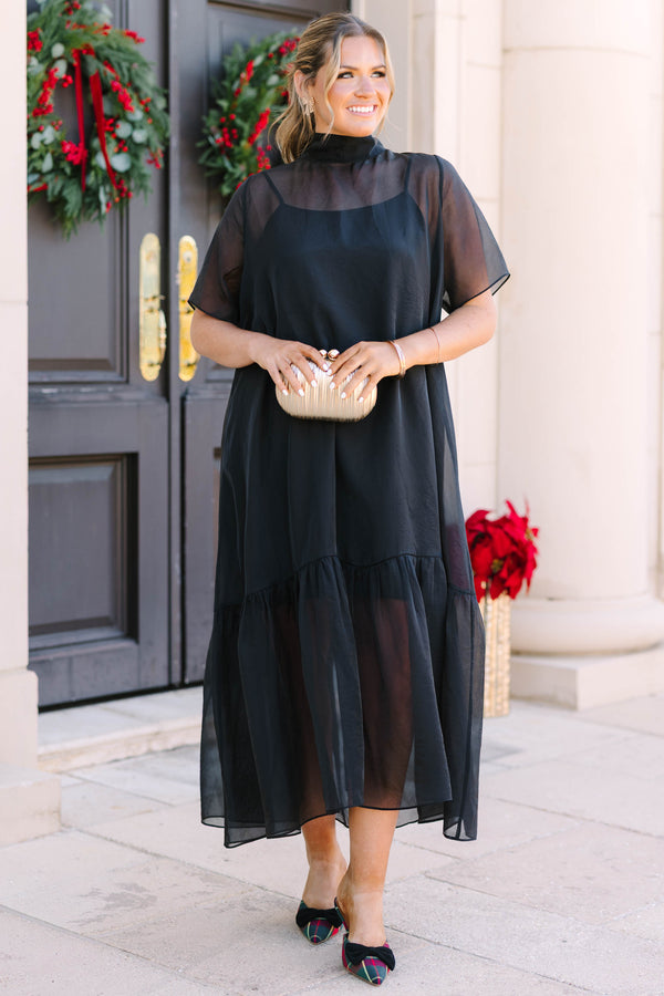 Plus Size black midi dress with a high neck, sheer overlay, short sleeves, and a ruffled hem.
