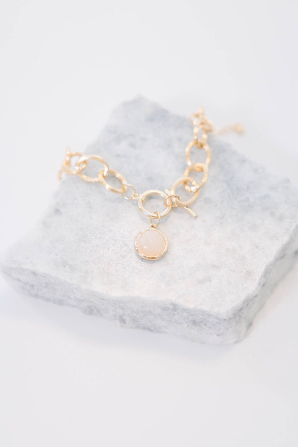 Plus Size gold chain link bracelet with a round white stone charm and toggle closure.