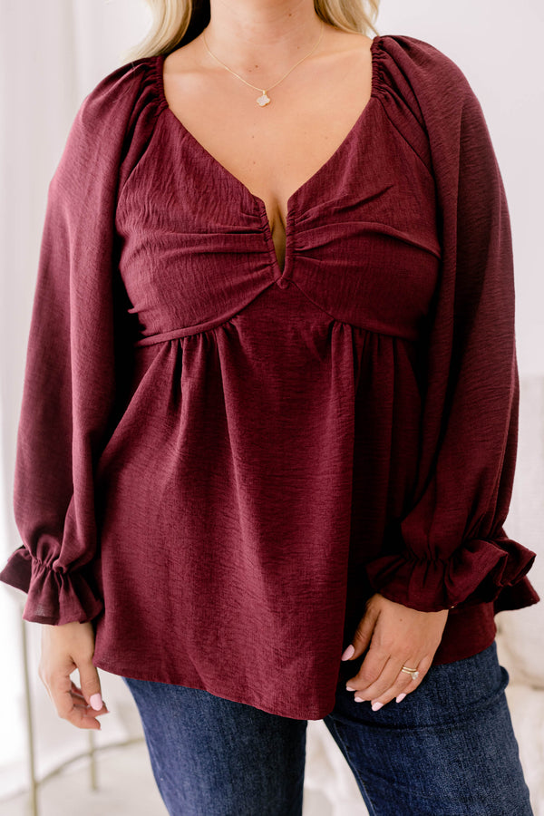 Chic Soul plus size clothing, maroon long sleeve flowy baby doll blouse with a structured v neckline and ruffles on the ends of the sleeves