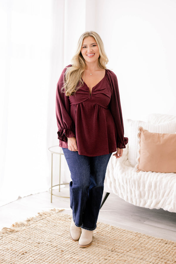 Chic Soul plus size clothing, maroon long sleeve flowy baby doll blouse with a structured v neckline and ruffles on the ends of the sleeves