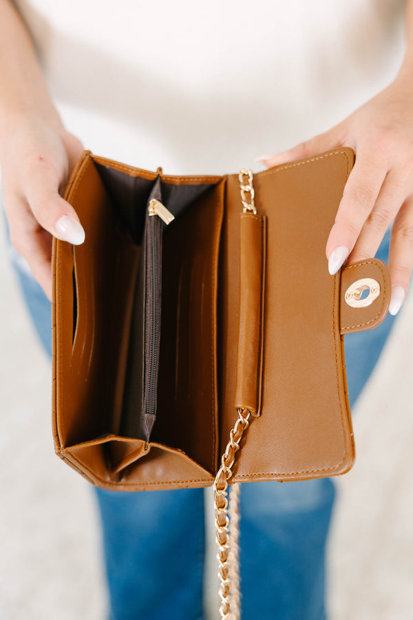 Plus Size brown quilted crossbody purse with a gold chain strap, worn with a white tee and jeans.