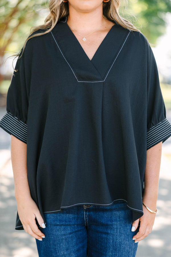 Plus Size black v-neck top with white contrast stitching on the neckline, cuffs, and hem.