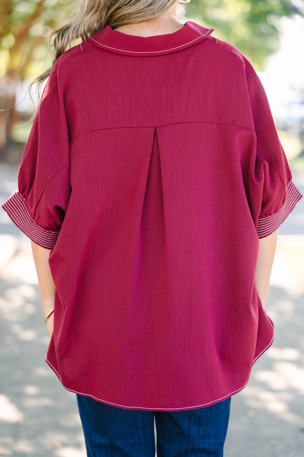 Plus size burgundy top with a flowy fit, V-neck, and striped sleeve details.