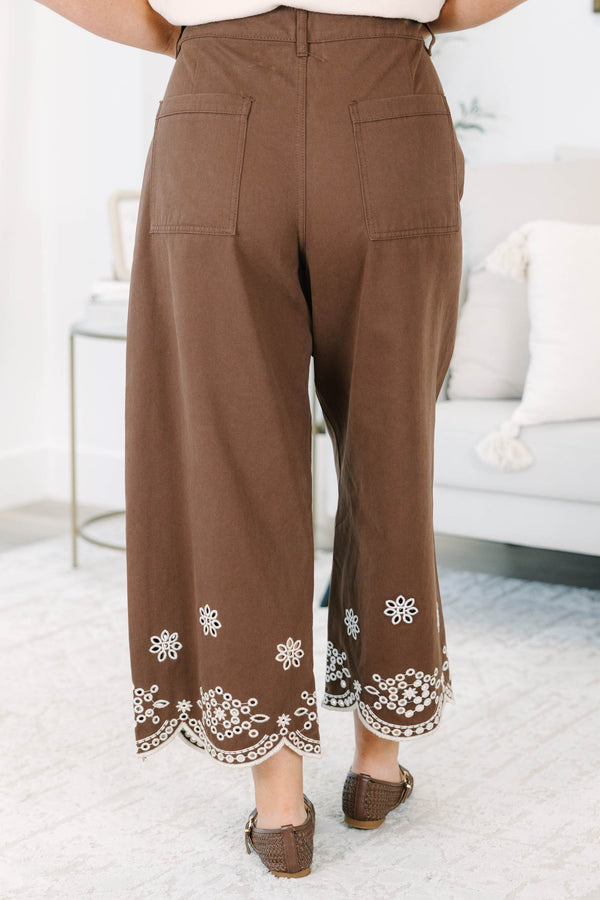 Plus Size brown high-rise wide-leg jeans with white floral embroidery and scalloped eyelet hems.