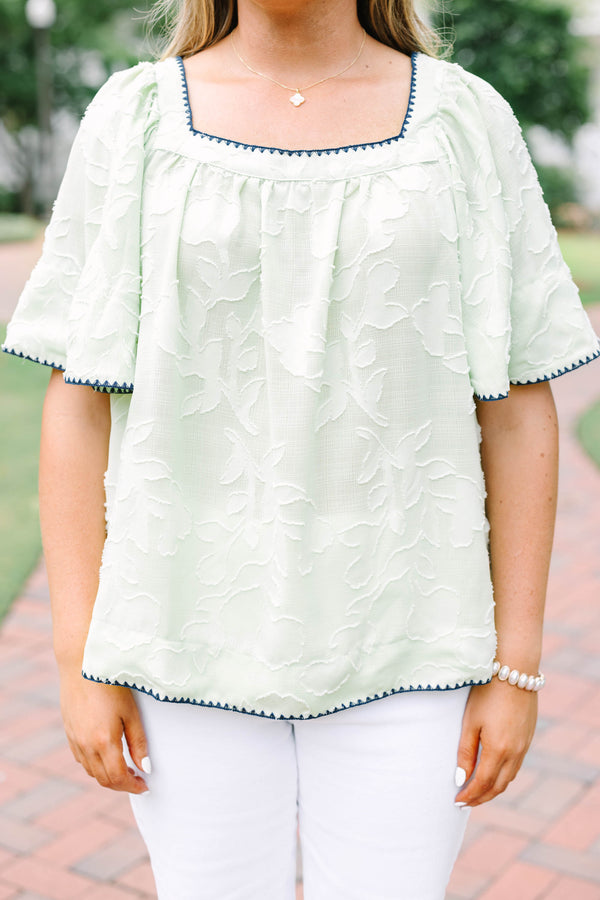 Plus Size light green floral textured top with navy scalloped trim and short flutter sleeves.