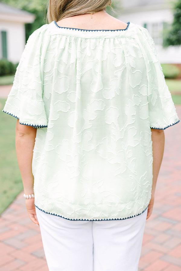 Plus Size light green floral textured top with navy scalloped trim and short flutter sleeves.