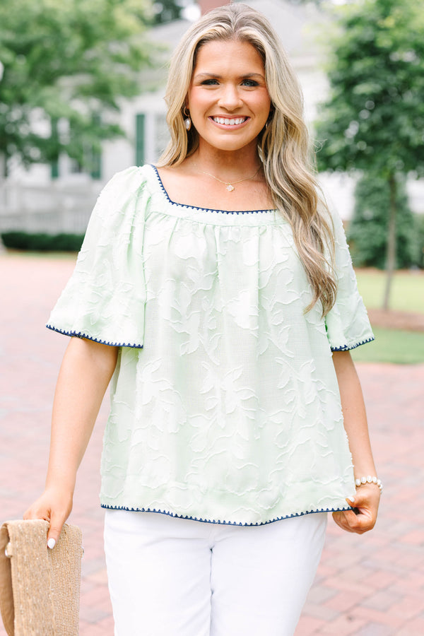 Plus Size light green floral textured top with navy scalloped trim and short flutter sleeves.