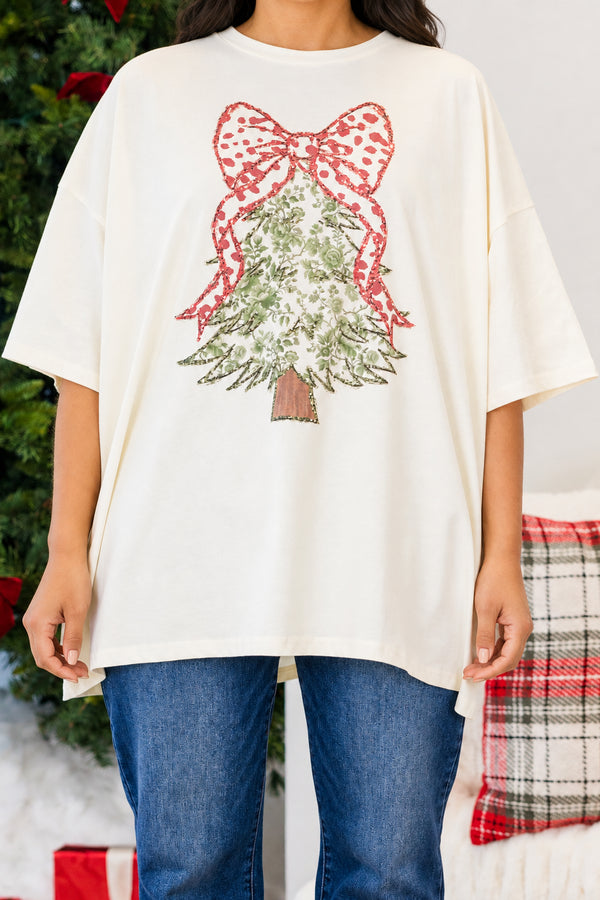 Chic Soul plus size clothing. Oversized ivory boyfriend tee featuring a festive Christmas tree graphic with a green floral pattern and a large red patterned bow.