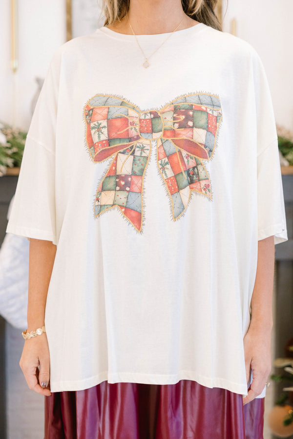 Chic Soul plus size clothing, off white oversized tee with a red and green patchwork style bow image on it