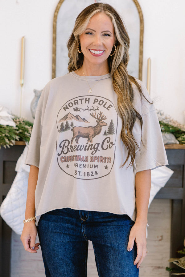 Chic Soul plus size clothing, stone tan short sleeve slightly cropped vintage wash tee with “North Pole Brewing Co. Christmas Spirits Premium Ext. 1824” text on the front with a reindeer mountains and tree