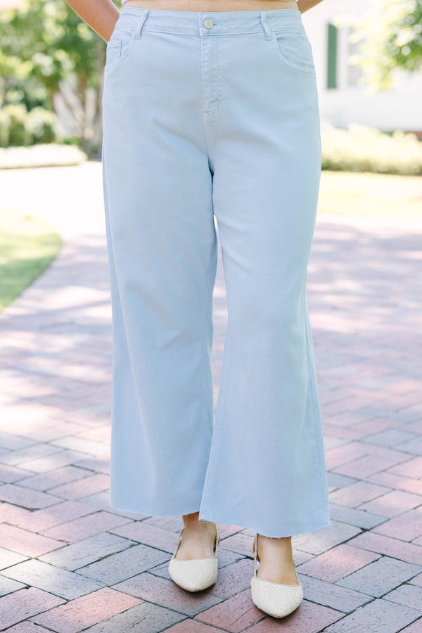 Plus Size light blue high rise crop wide leg jeans with a frayed hemline.