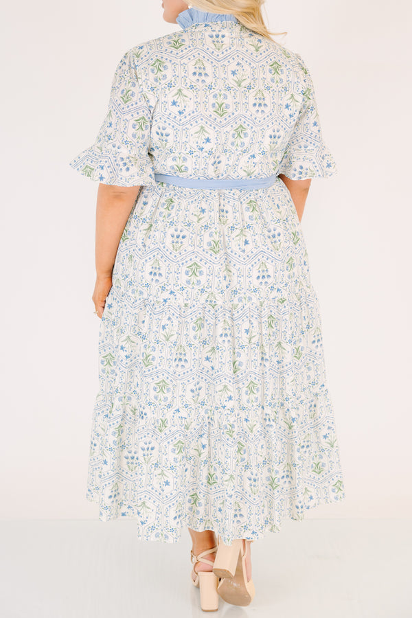 Chic Soul plus size clothing, blue maxi dress with shorts sleeves that flare out a blue multi floral pattern and a blue belt that ties into a bow that goes around the waist as blue ruffling details going along the neckline 