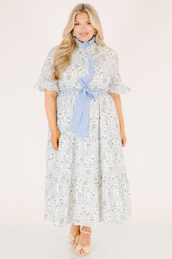 Chic Soul plus size clothing, blue maxi dress with shorts sleeves that flare out a blue multi floral pattern and a blue belt that ties into a bow that goes around the waist as blue ruffling details going along the neckline 