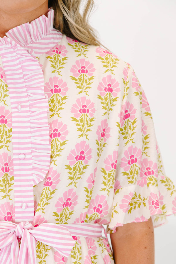 Plus size pink floral midi dress with a ruffle collar, striped waist tie, and flowy tiered skirt.