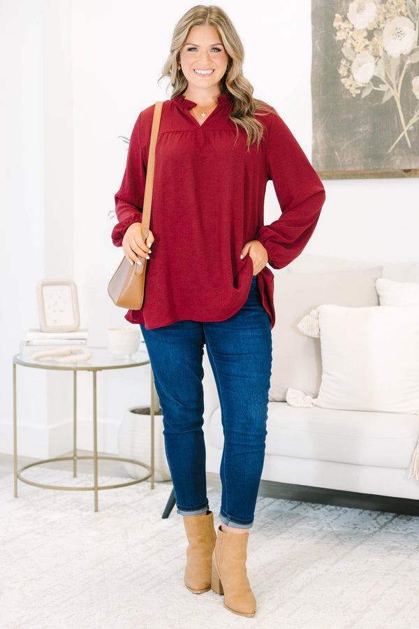 Plus size burgundy flowy long sleeve top with a ruffled V-neckline and relaxed fit.