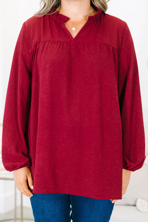 Plus size burgundy flowy long sleeve top with a ruffled V-neckline and relaxed fit.