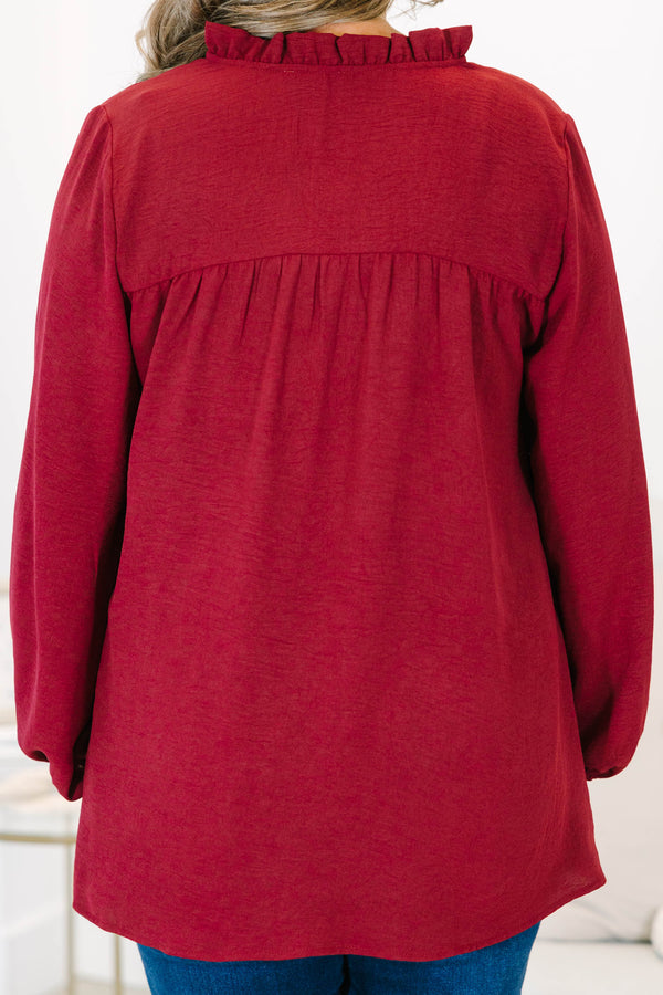 Plus size burgundy flowy long sleeve top with a ruffled V-neckline and relaxed fit.
