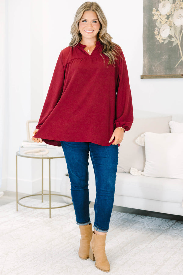 Plus size burgundy flowy long sleeve top with a ruffled V-neckline and relaxed fit.