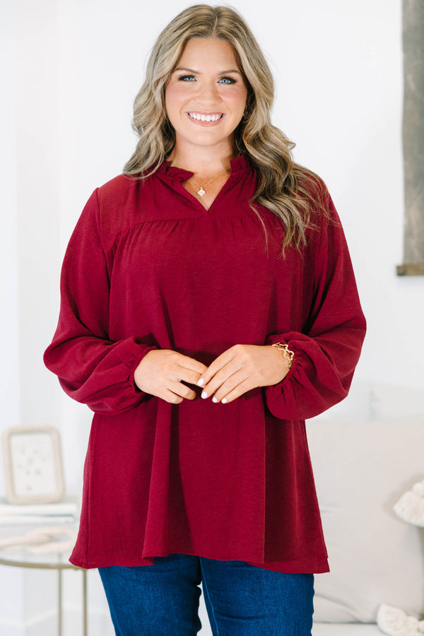 Plus size burgundy flowy long sleeve top with a ruffled V-neckline and relaxed fit.