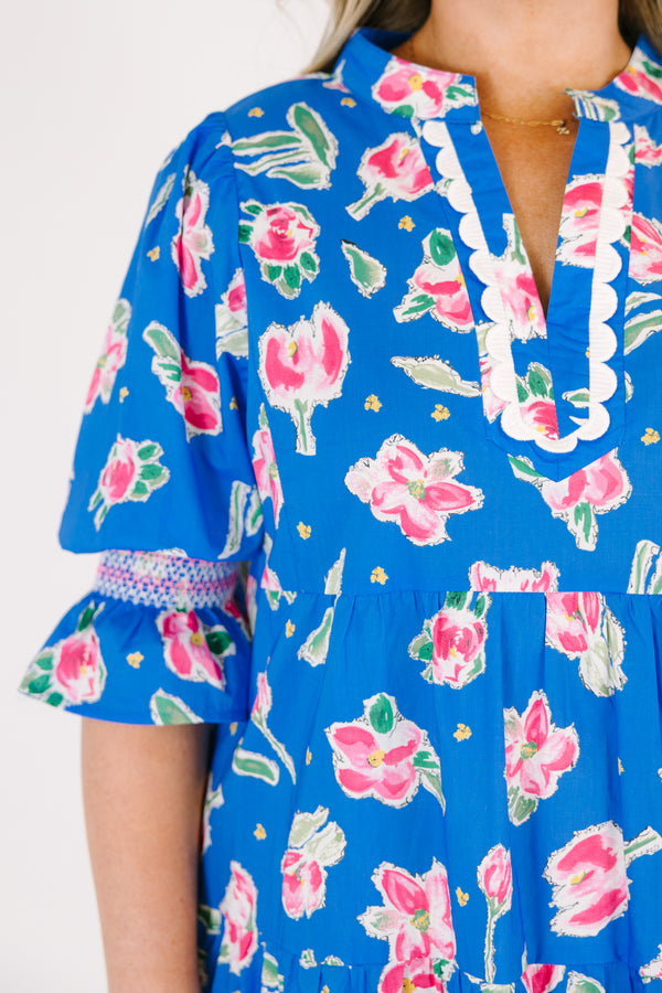 Chic Soul plus size clothing, cobalt tiered knee length dress with half sleeves that have a ruffle flare at the end of each sleeve as well as a pink floral pattern throughout and scalloped detailing on the v-neckline 