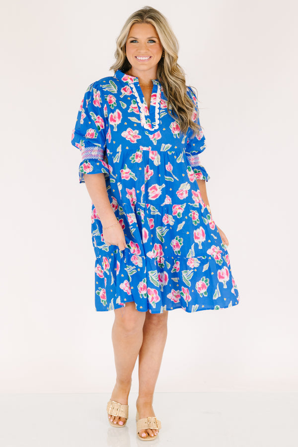 Chic Soul plus size clothing, cobalt tiered knee length dress with half sleeves that have a ruffle flare at the end of each sleeve as well as a pink floral pattern throughout and scalloped detailing on the v-neckline 