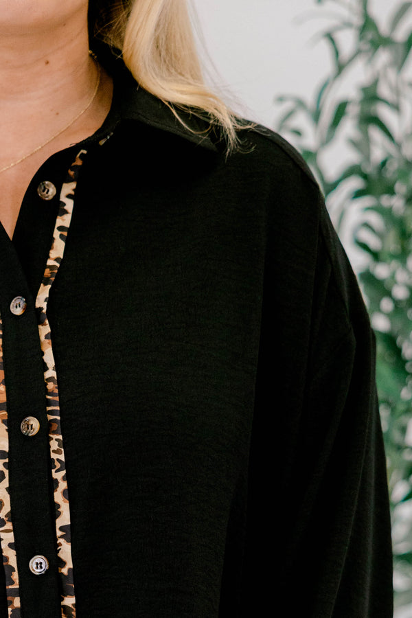 Chic Soul plus size clothing, black long sleeve top with a flare at the bottom as well as leopard stitching details at the bottom of each sleeve going down the center of the shirt and on the bottom of the shirt 