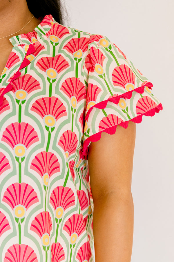 Chic Soul plus size clothing, pink top with flutter sleeves that have a pink scalloped detail outlining the ends of each ruffle as well as going along the v-neckline and a floral block pattern throughout 