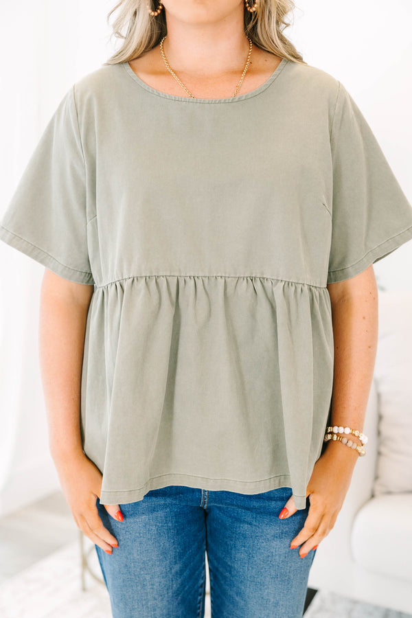 Plus Size olive green short sleeve babydoll top with a round neckline and ruffled waist seam.