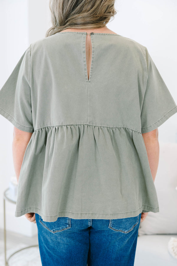 Plus Size olive green short sleeve babydoll top with a round neckline and ruffled waist seam.