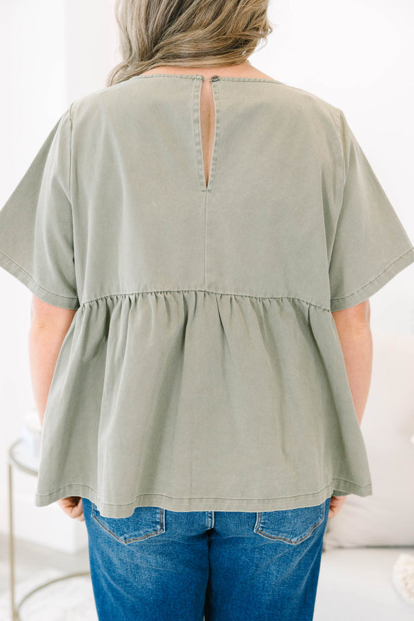 Plus Size olive green short sleeve babydoll top with a round neckline and ruffled waist seam.