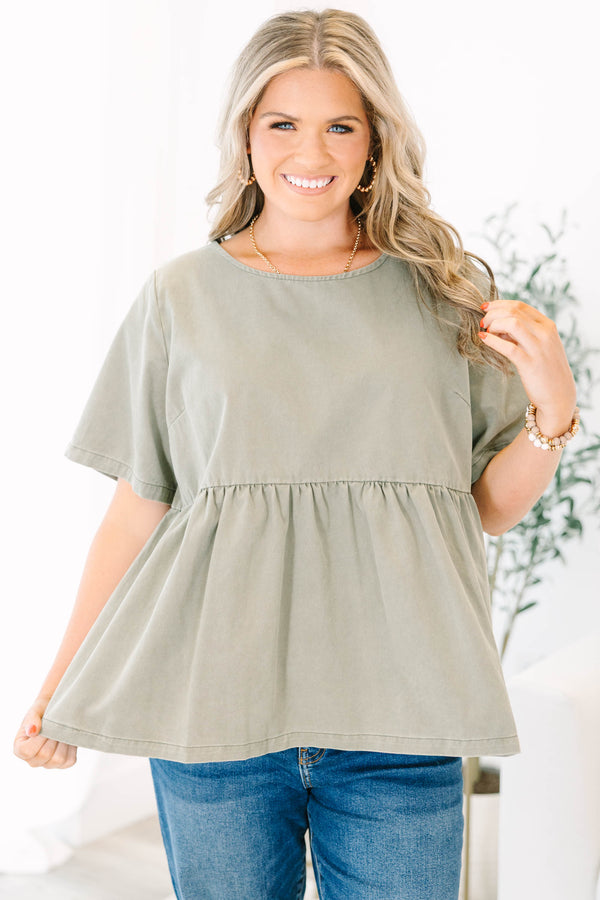 Plus Size olive green short sleeve babydoll top with a round neckline and ruffled waist seam.