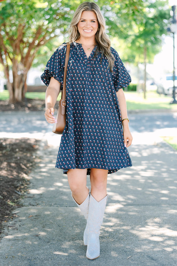 Plus size navy shift dress with red and white polka dots, featuring a flowy fit and V-neckline.