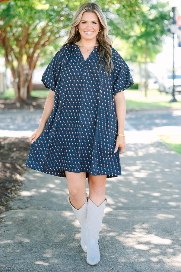 Plus size navy shift dress with red and white polka dots, featuring a flowy fit and V-neckline.